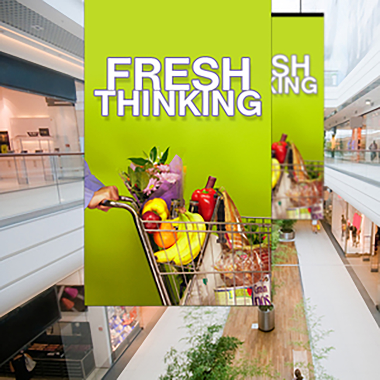 A large vertical banner in a shopping mall displays the words