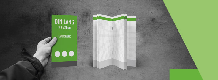 Zwei farbige Broschüren im DIN-A4-Format mit grüner Gestaltung und der Aufschrift „einszweidrei“ unten; eine Broschüre wird von einer Hand gehalten, die andere steht aufrecht auf einer Holzoberfläche.