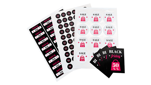 Verschiedene Bögen mit Aufklebern für den Black Friday-Verkauf, darunter Etiketten mit Aufschriften wie „SALE 50%“ und „TOTAL SALE“, gestaltet in Schwarz, Weiß und Rosa.