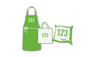 Eine weiße Baseballkappe, ein graues Poloshirt und eine beige Tragetasche, alle mit einem grün-weißen Logo mit kreisförmigen Elementen; auf der Tragetasche sind außerdem Social-Media-Symbole und das Wort „einszweidrei“ abgebildet.