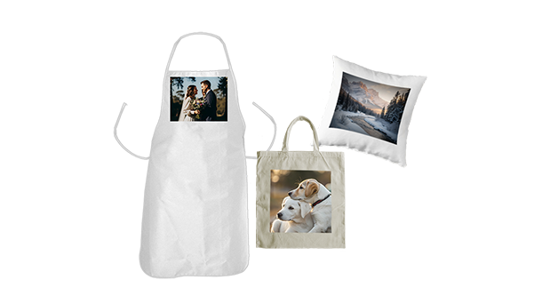 Eine weiße Schürze mit dem Foto eines Paares, eine beige Tragetasche mit dem Bild zweier Hunde und ein weißes Kissen mit einem Landschaftsfoto werden ausgestellt und präsentieren individualisierbare Textilprodukte.